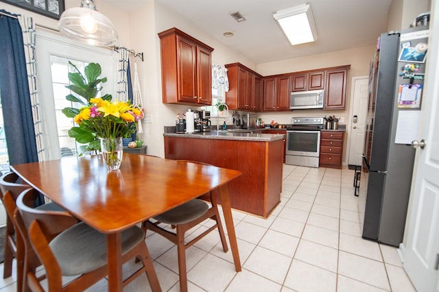kitchen with a peninsula, visible vents, stainless steel appliances, and light tile patterned floors