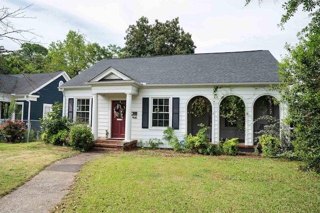 view of front of property featuring fence, a shingled roof, and a front yard