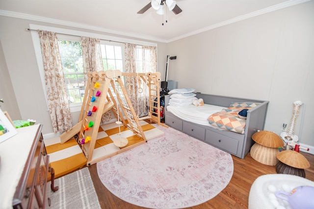 bedroom with multiple windows, wood finished floors, ceiling fan, and ornamental molding