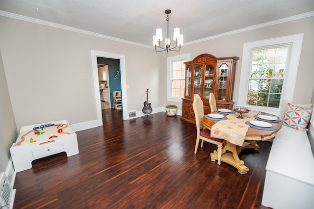 dining space featuring an inviting chandelier, ornamental molding, wood finished floors, and plenty of natural light
