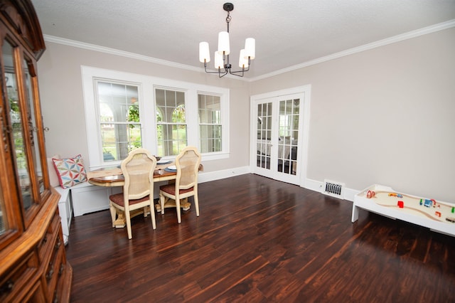dining room with wood finished floors, a chandelier, baseboards, ornamental molding, and visible vents