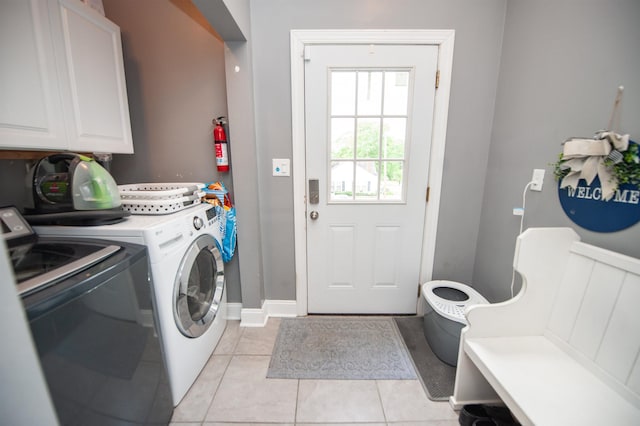laundry room featuring cabinet space, independent washer and dryer, and light tile patterned flooring