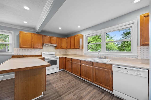 kitchen featuring recessed lighting, plenty of natural light, under cabinet range hood, a sink, and white appliances