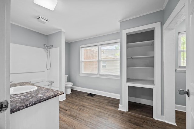full bathroom with wood finished floors, crown molding, baseboards, and toilet