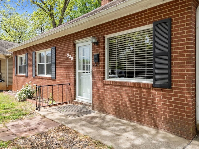 doorway to property with brick siding