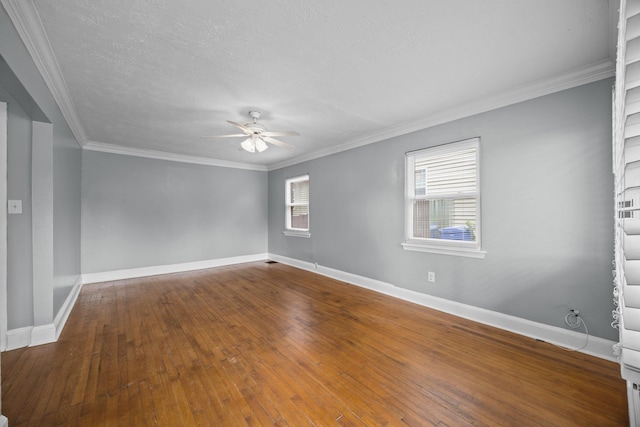 empty room with hardwood / wood-style floors, ornamental molding, baseboards, and ceiling fan