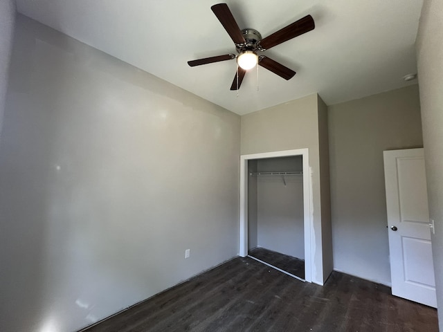 unfurnished bedroom with ceiling fan, dark wood-style floors, and a closet