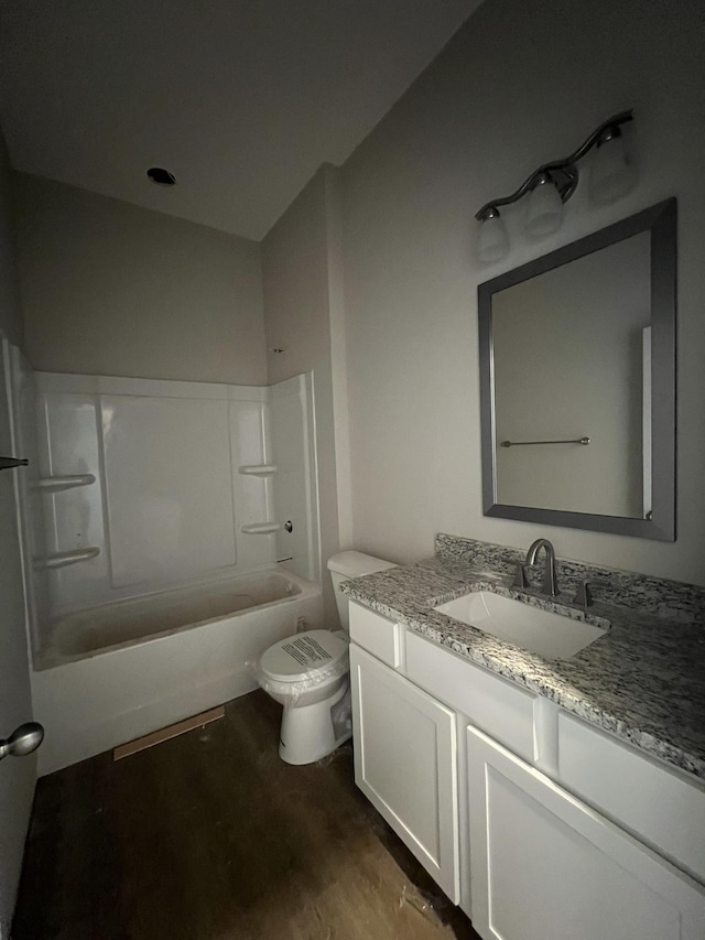 bathroom featuring toilet, vanity, wood finished floors, and shower / tub combination