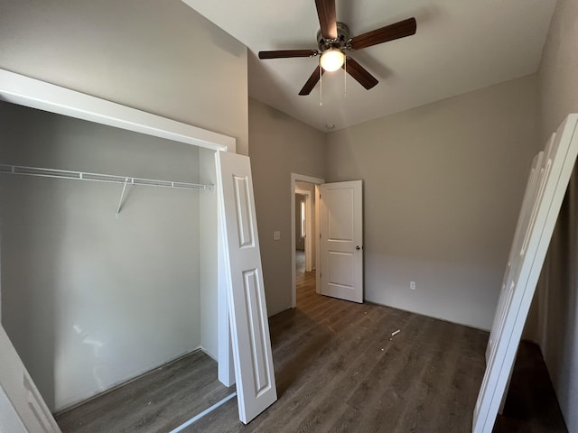 unfurnished bedroom featuring dark wood-type flooring, a closet, high vaulted ceiling, and ceiling fan