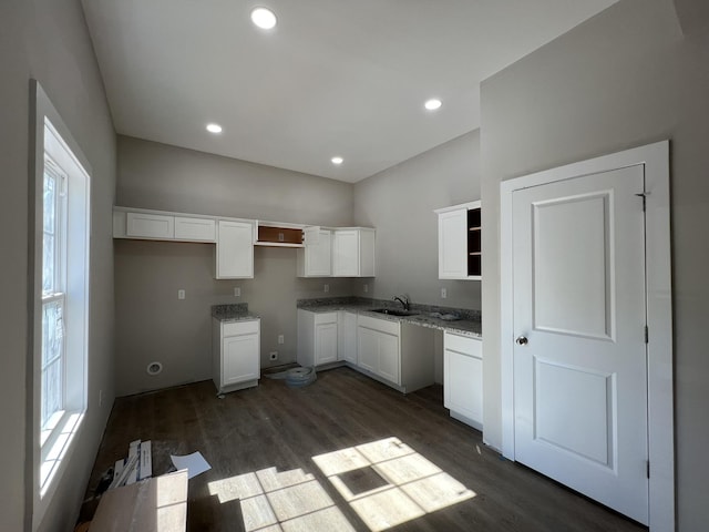 kitchen with white cabinets, a sink, recessed lighting, open shelves, and dark wood-type flooring