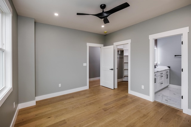 unfurnished bedroom featuring baseboards, recessed lighting, a spacious closet, a closet, and connected bathroom