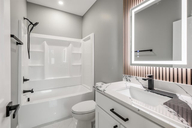 bathroom featuring shower / washtub combination, marble finish floor, vanity, and toilet