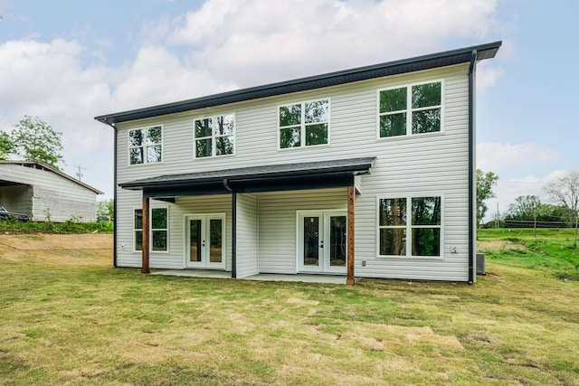 back of property with a yard and french doors
