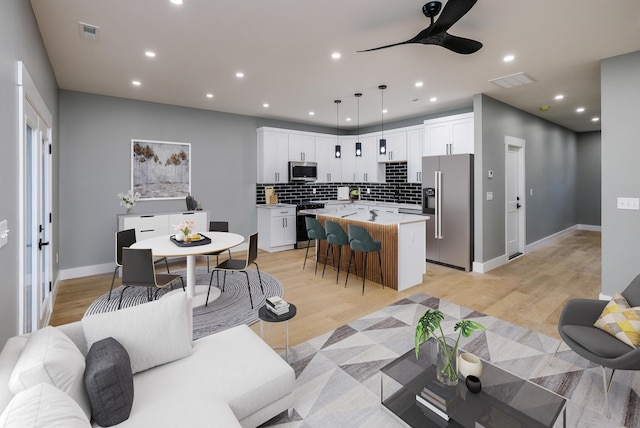 living area with a ceiling fan, visible vents, and recessed lighting