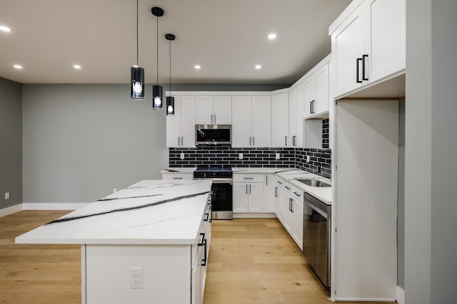 kitchen featuring tasteful backsplash, stainless steel appliances, light wood finished floors, a kitchen island, and recessed lighting