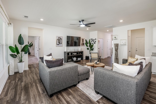 living room featuring visible vents, a ceiling fan, and dark wood-style flooring