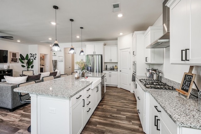 kitchen featuring white cabinetry, light stone counters, appliances with stainless steel finishes, dark wood-style floors, and open floor plan