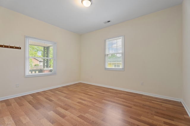 spare room with baseboards, visible vents, and light wood-style flooring