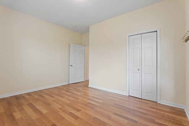 unfurnished bedroom featuring baseboards and light wood-type flooring