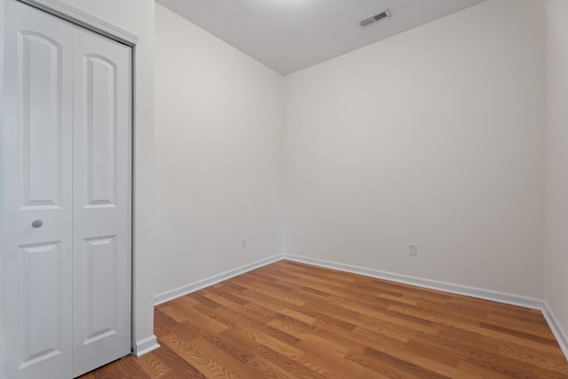 spare room featuring baseboards, visible vents, and light wood finished floors