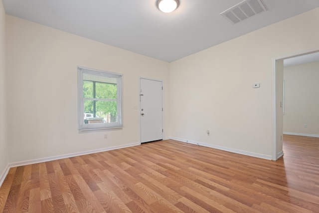 empty room featuring baseboards, visible vents, and light wood-style floors