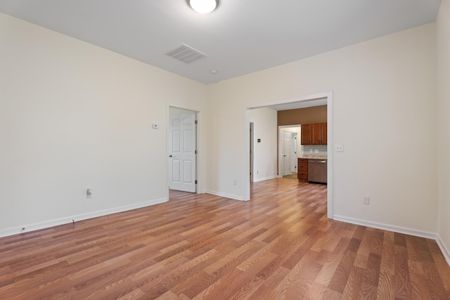 spare room featuring baseboards, visible vents, and light wood-style flooring