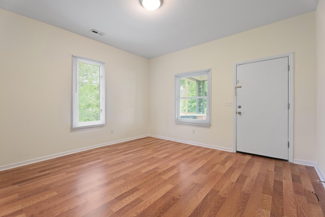spare room with baseboards, visible vents, light wood-type flooring, and plenty of natural light