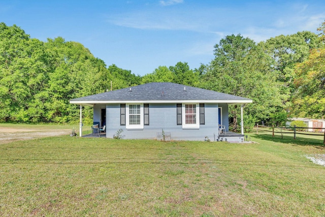 back of property with a lawn, roof with shingles, a patio, and fence