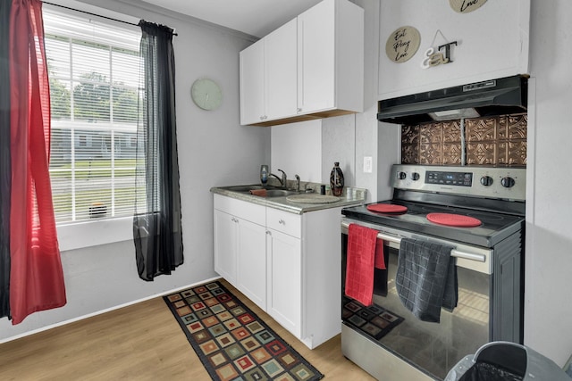 kitchen with white cabinets, stainless steel electric stove, under cabinet range hood, and light wood-style floors