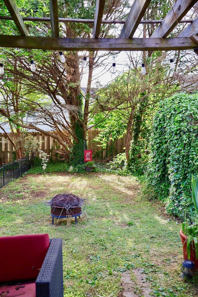 view of yard with a fire pit, a pergola, and a fenced backyard