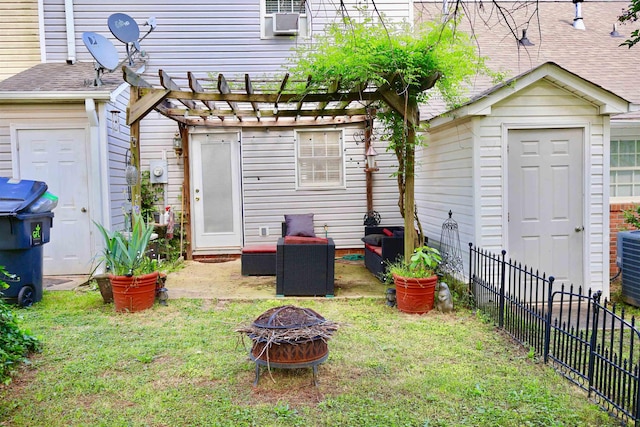 back of house with fence, a fire pit, a pergola, and a yard