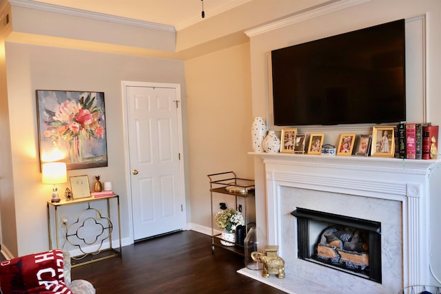 living area with dark wood-style floors, a fireplace, crown molding, visible vents, and baseboards