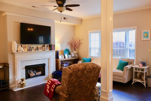 living area with ornamental molding, wood finished floors, a ceiling fan, and visible vents