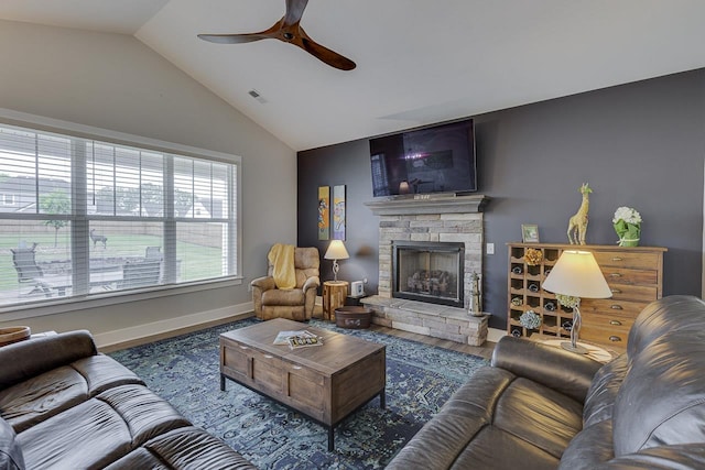 living room featuring wood finished floors, ceiling fan, a fireplace, baseboards, and lofted ceiling