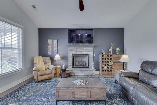 living room featuring visible vents, wood finished floors, a fireplace, and plenty of natural light