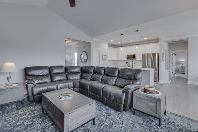 living area featuring recessed lighting, light wood-style flooring, baseboards, ornamental molding, and lofted ceiling