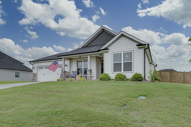 craftsman inspired home featuring a front lawn, a garage, covered porch, driveway, and fence