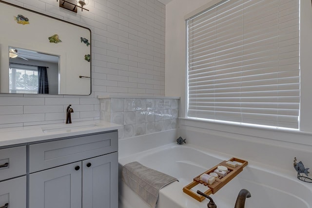 bathroom with a bath, vanity, and tasteful backsplash