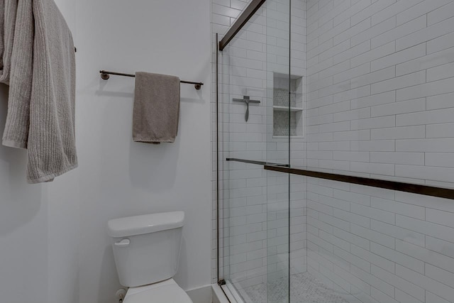 bathroom featuring a shower stall and toilet