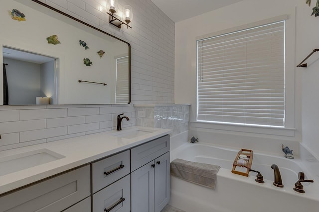 bathroom with tasteful backsplash, double vanity, a bath, and a sink