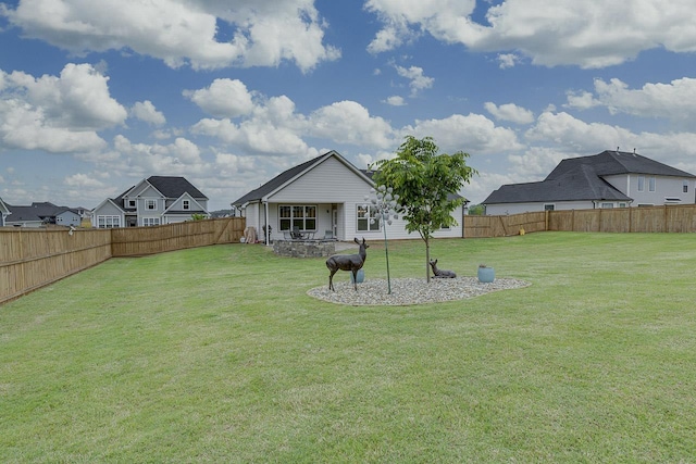 back of property with a lawn, a fenced backyard, and a patio area