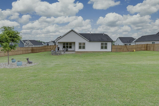 rear view of property featuring a patio, a yard, and a fenced backyard