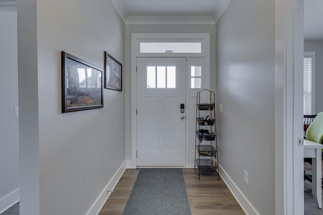 entrance foyer featuring dark wood-style flooring, crown molding, and baseboards