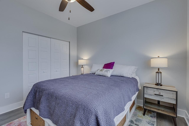 bedroom featuring baseboards, wood finished floors, a ceiling fan, and a closet