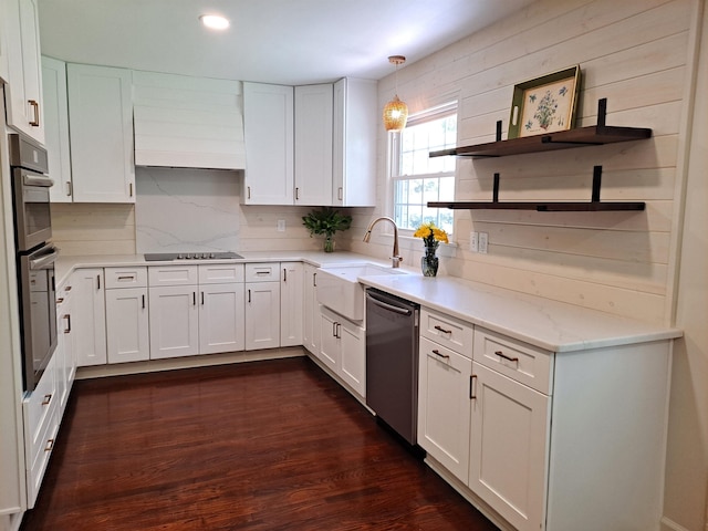 kitchen featuring light stone countertops, white cabinets, dark wood-style flooring, dishwasher, and a sink