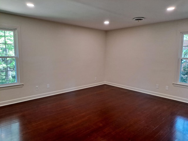 unfurnished room featuring baseboards, recessed lighting, a healthy amount of sunlight, and dark wood-style flooring