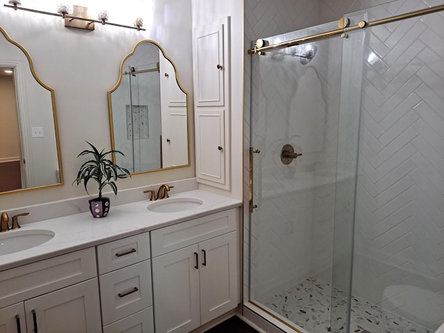 bathroom featuring double vanity, a stall shower, and a sink