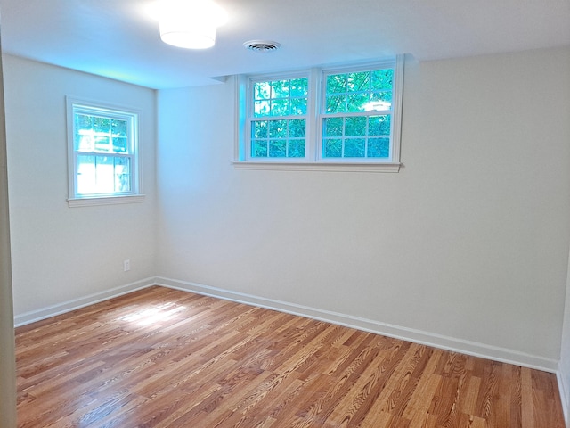 spare room featuring baseboards, visible vents, and light wood-style flooring