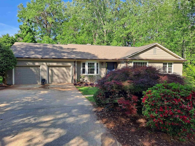 ranch-style house featuring driveway and an attached garage