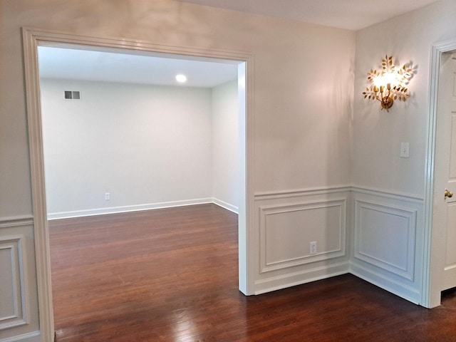 unfurnished room with dark wood-style floors and visible vents